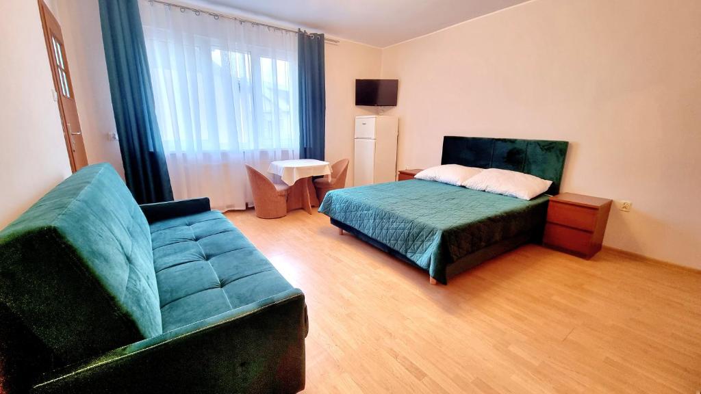 1 dormitorio con sofá, cama y silla en Pokoje Arka, en Międzywodzie