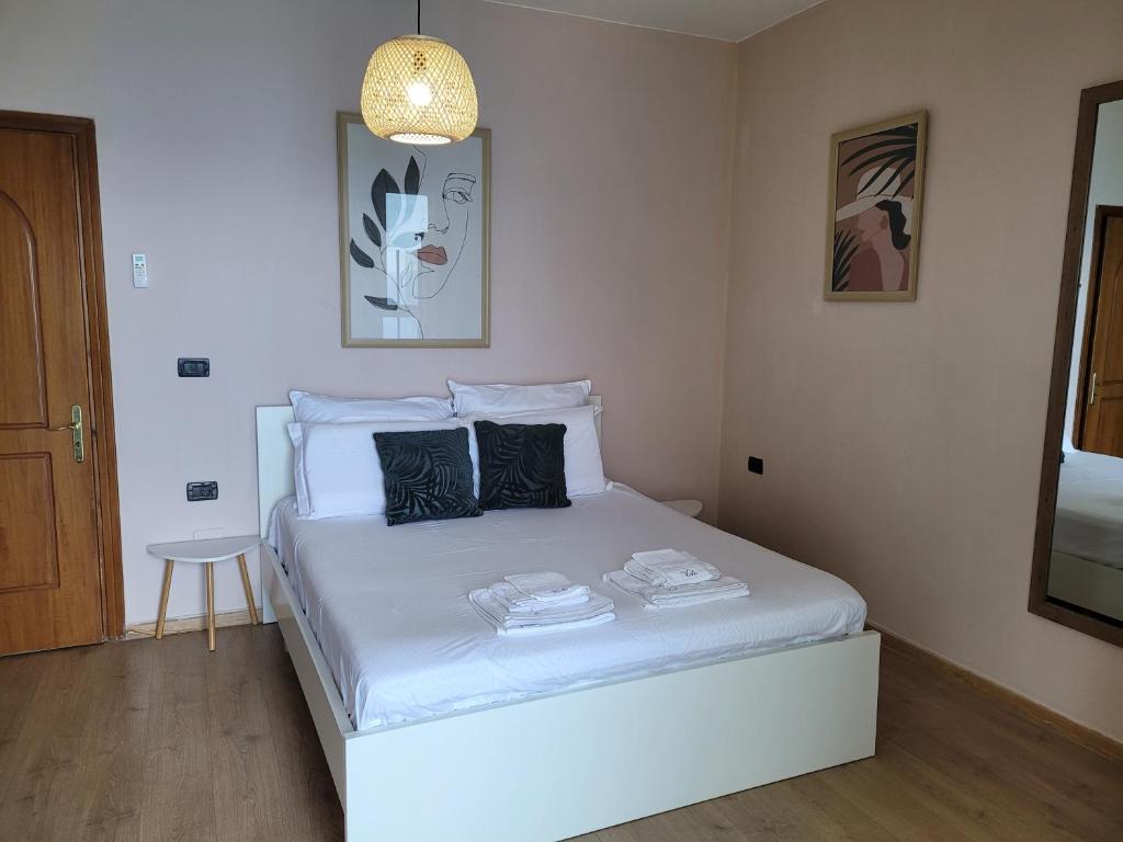 Un dormitorio con una cama blanca en una habitación. en Villa Angela, en Vlorë
