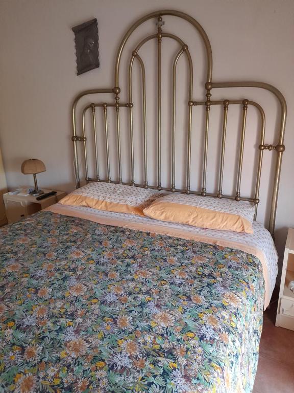 1 dormitorio con 1 cama con colcha de flores en Appartamento Rosati, en Oliveri