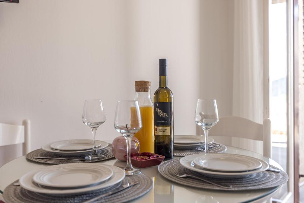 a table with glasses and a bottle of wine at Family Apartments Jadrijević in Primošten