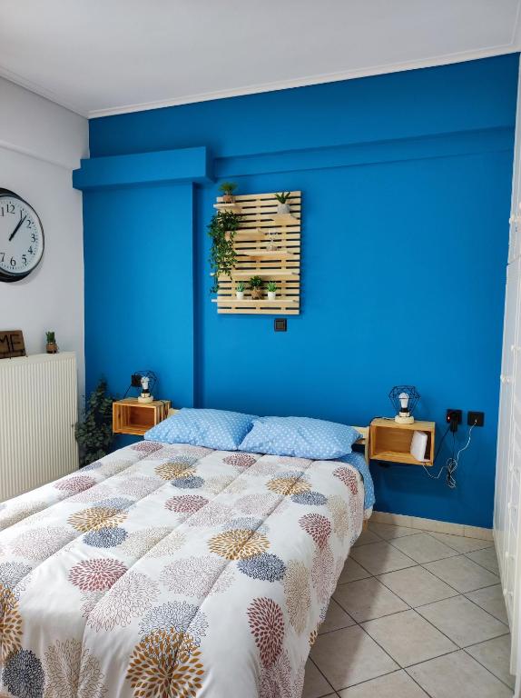 ein Schlafzimmer mit einer blauen Wand und einem Bett in der Unterkunft Blue Lagoon Studio 2 in Mesolongi