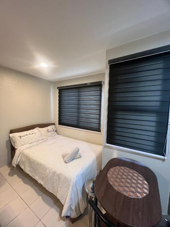 1 dormitorio con 1 cama y 2 ventanas con persianas en Cozy Boo Staycation near Enchanted kingdom by Dynel, en Santa Rosa