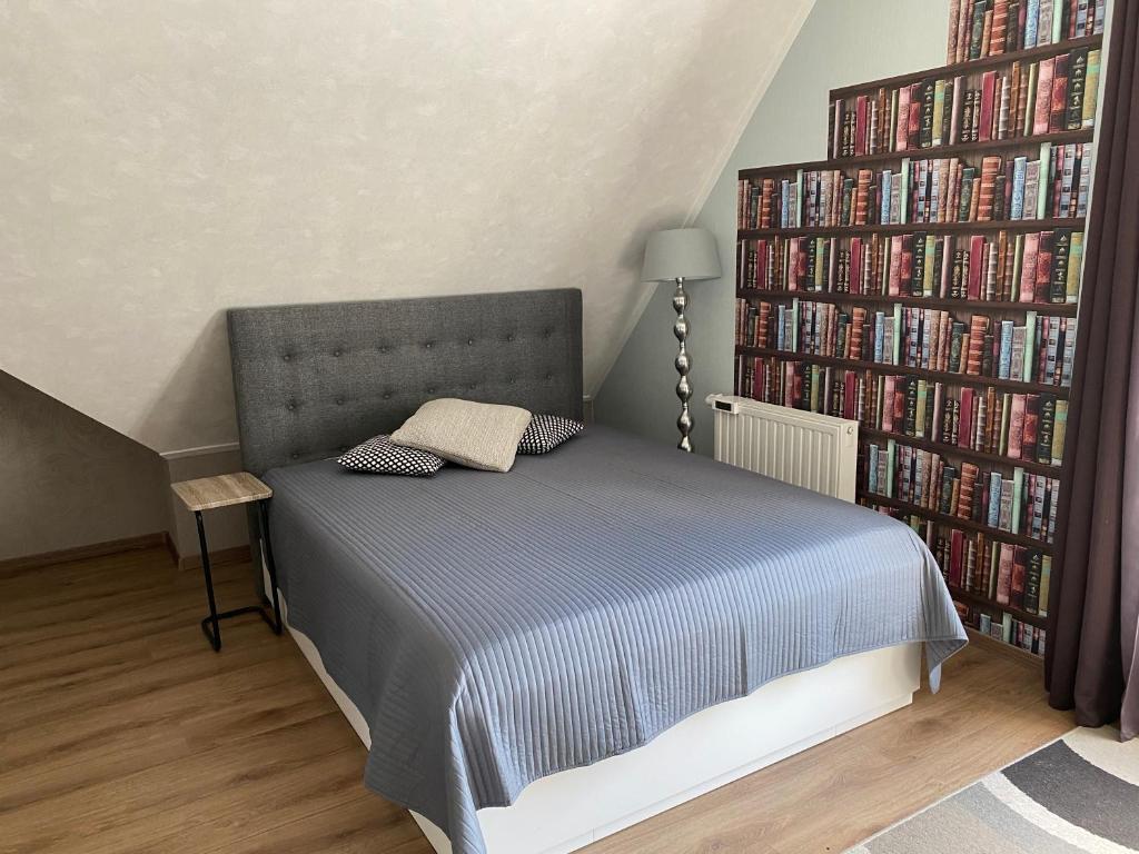 Un dormitorio con una cama y una estantería llena de libros. en Zoutelande,modern verblijf bij de zee, en Zoutelande