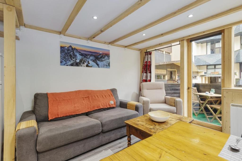 ein Wohnzimmer mit einem Sofa und einem Tisch in der Unterkunft Modern Apart 2BR Close to Grand Montets Lift in Chamonix-Mont-Blanc