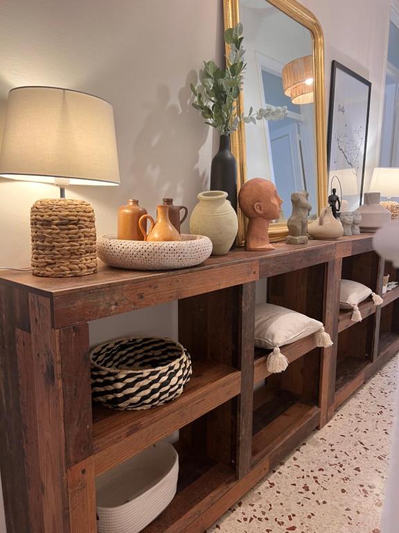 a wooden shelf with vases and a lamp on it at Apartament BellaPola Trapani in Trapani