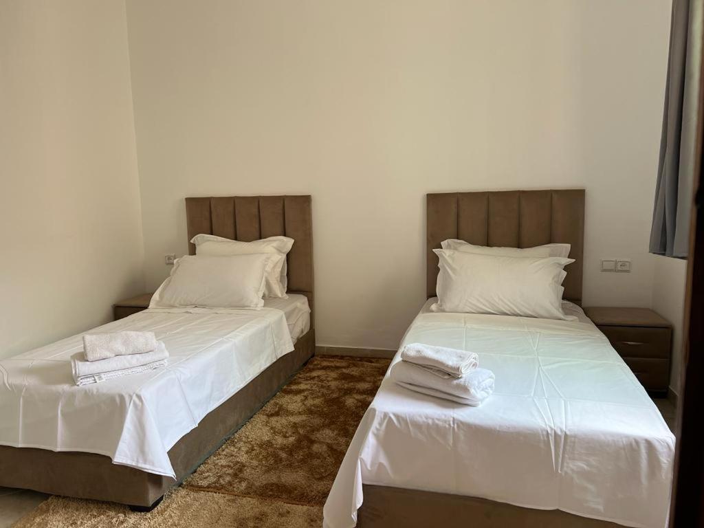 een slaapkamer met 2 bedden en witte lakens bij Perfect only family apartment & air cooling in Marrakesh