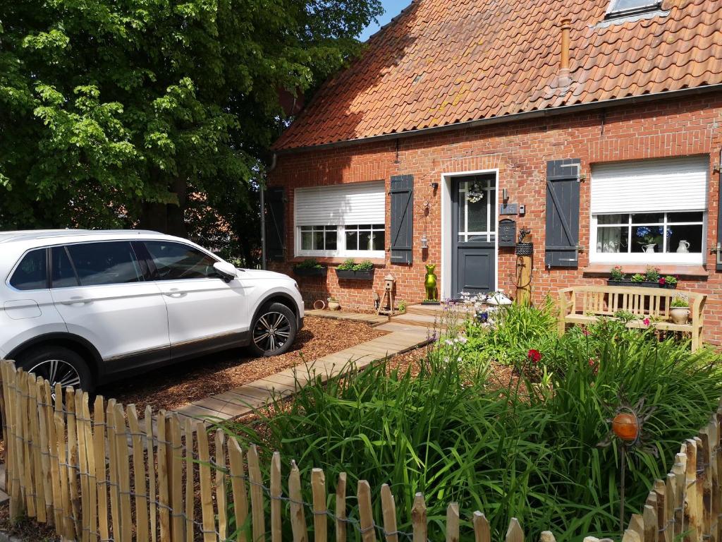 une voiture blanche garée devant une maison dans l'établissement Huus an`t Dörpsdiek, à Krummhörn