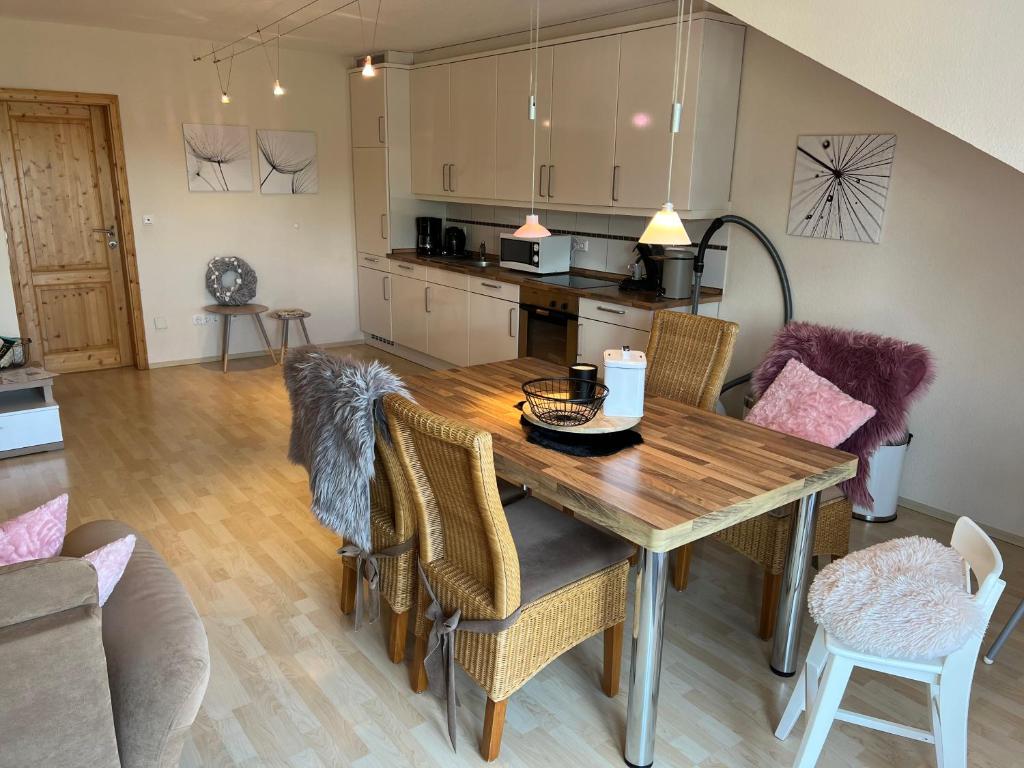 a kitchen and dining room with a wooden table and chairs at Schmidt's Plaats in Norden