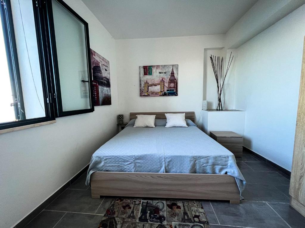 ein Schlafzimmer mit einem Bett und einem großen Fenster in der Unterkunft U Castiddanu breathtaking view in Taormina