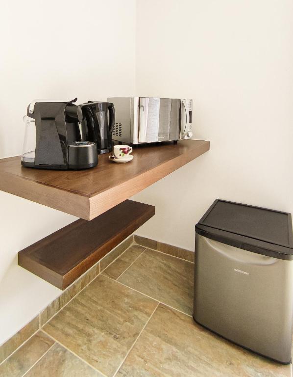 a kitchen with a shelf with a trash can at Quinta dos Padrinhos - Suites in the Heart of the Douro in Lamego