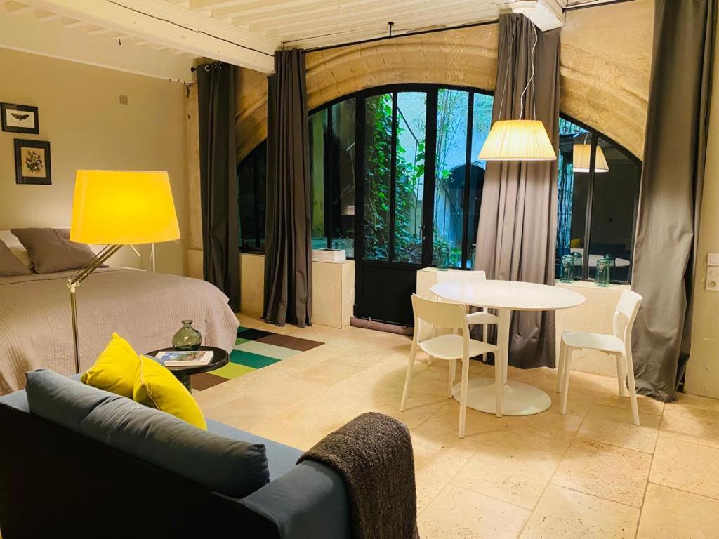 un salon avec un lit, une table et des chaises dans l'établissement Studio de l'Atelier d'Artiste, à Avignon