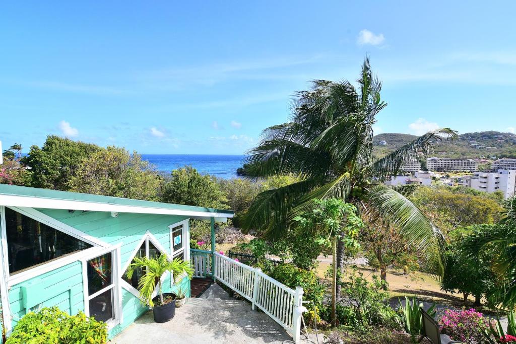 a house with a balcony with a view of the ocean at Beachfront Cottage in Gros Islet