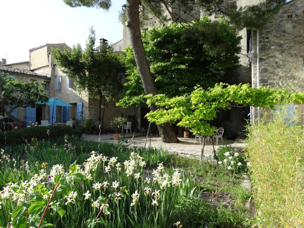 un jardin avec des fleurs blanches en face d'une maison dans l'établissement Le Clos du Tilleul, à Saint-Michel-lʼObservatoire