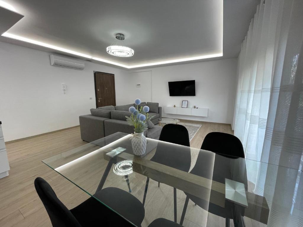 ein Wohnzimmer mit einem Glastisch und Stühlen in der Unterkunft New Bazaar 2022 in Tirana