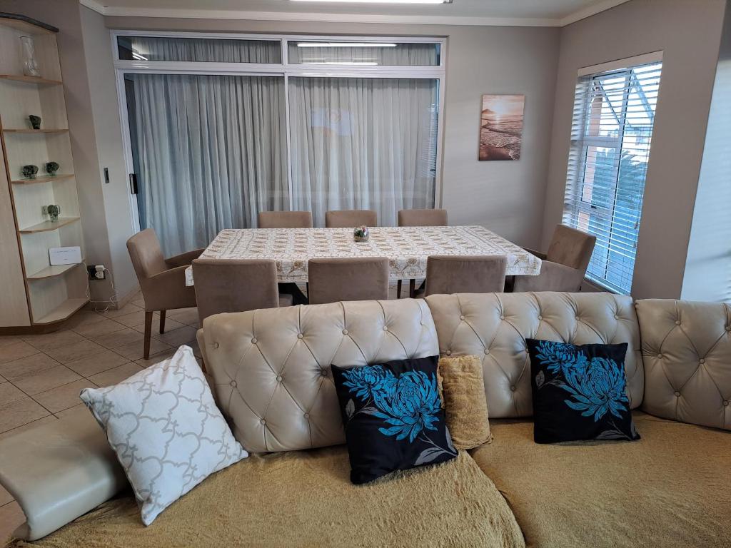 a living room with a couch and a dining room table at Beach Hive 1 in Swakopmund