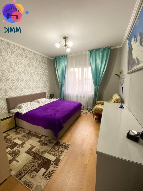 a bedroom with a purple bed and blue curtains at Dimm Отель in Almaty