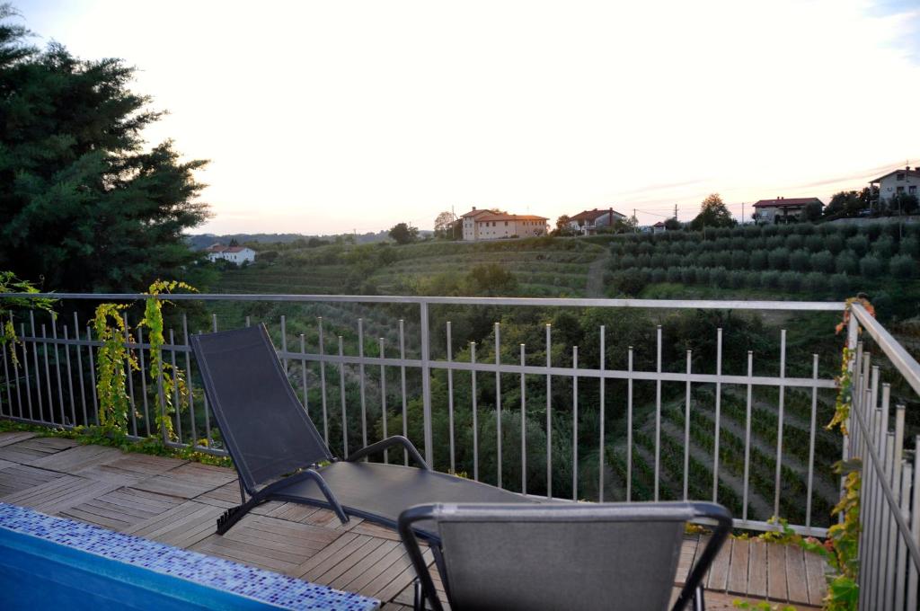 une chaise assise sur une terrasse à côté d'une clôture dans l'établissement Apartment in the heart of Brda wine region, Boris and Darinka Marinič, à Dobrovo