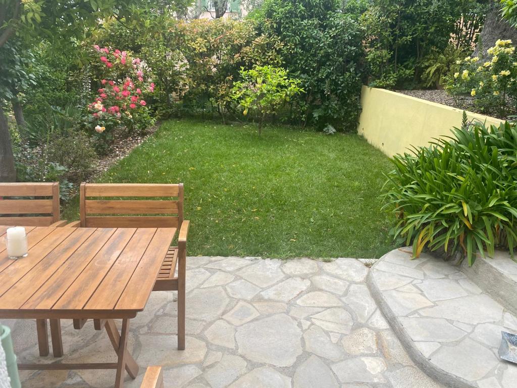 ニースにあるAppt avec jardin et clim proche Arènes de Cimiezの木製テーブルと椅子2脚