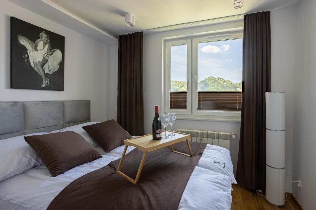 Schlafzimmer mit einem Bett mit einem Tisch und einem Fenster in der Unterkunft Apartament Czarny Flaming in Szczawnica