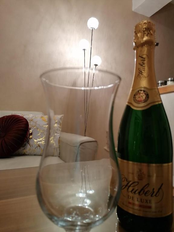 a bottle of champagne sitting next to a wine glass at Ubytovanie Sosna Muráň in Muráň