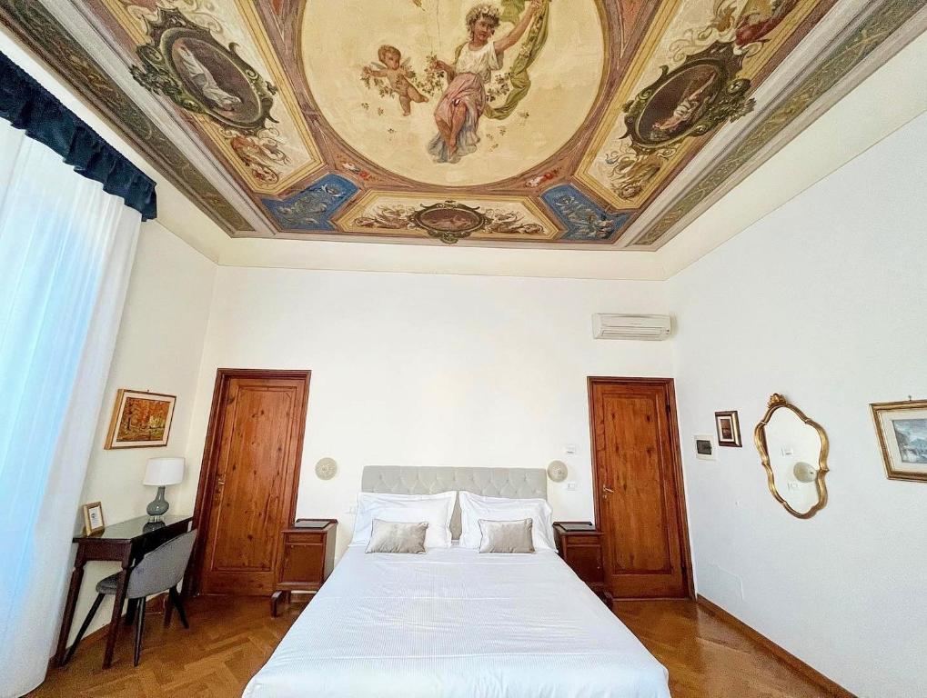 een slaapkamer met een groot bed en een schilderij aan het plafond bij Cimabue 9 in Florence