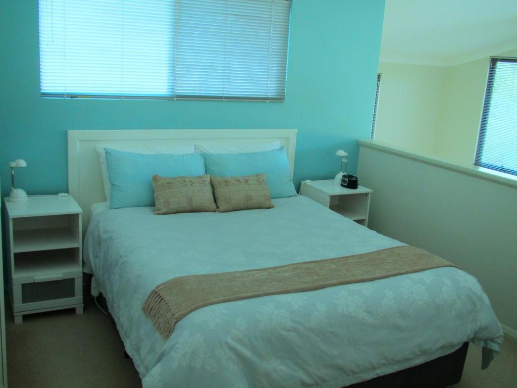 a bedroom with a large bed with blue walls at Hidden Grove Retreat in Boyup Brook