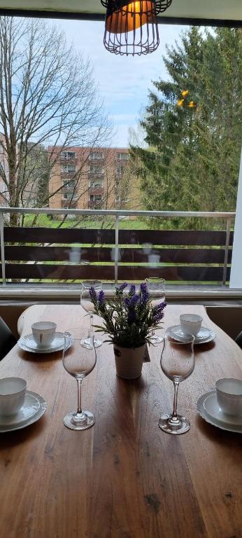 een houten tafel met stoelen en een vaas met bloemen erop bij FeWo Wanderlust in Altenau