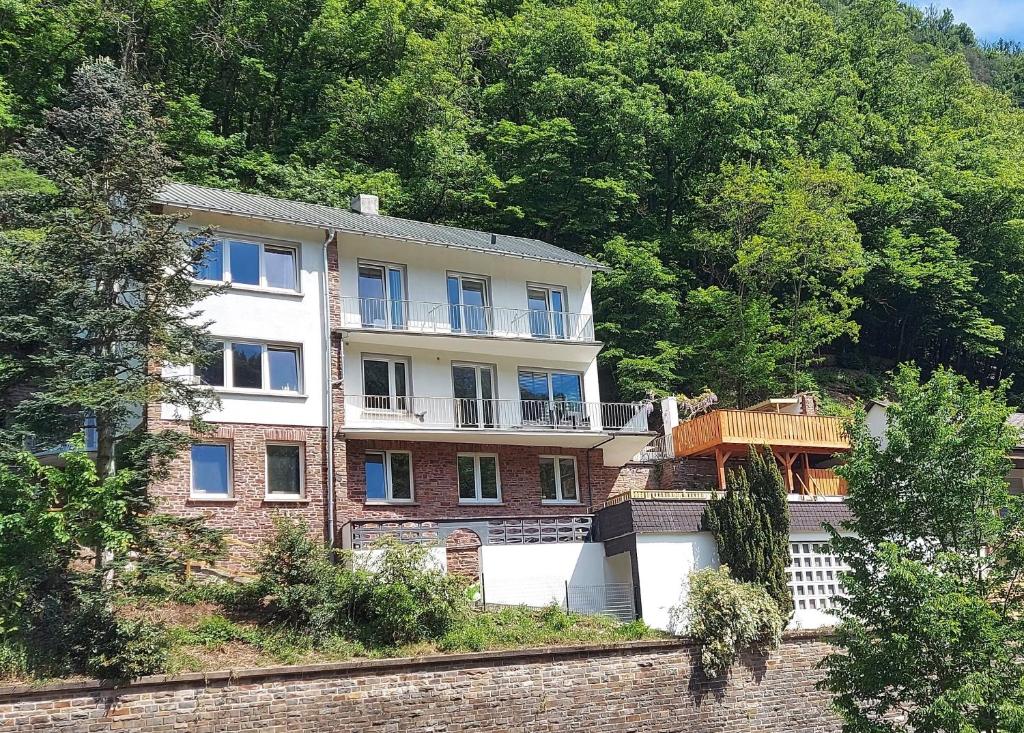 uma grande casa de tijolos numa colina com árvores em Villa Bad Bertrich em Bad Bertrich