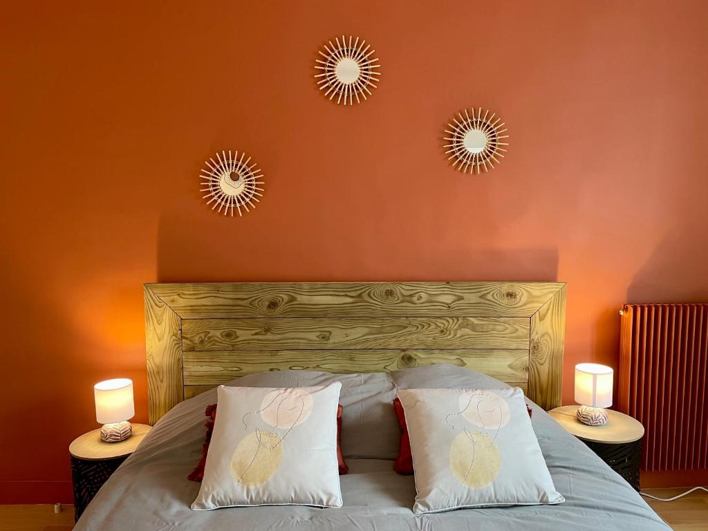 a bedroom with a bed with two mirrors on the wall at Le Cosy in Bayeux