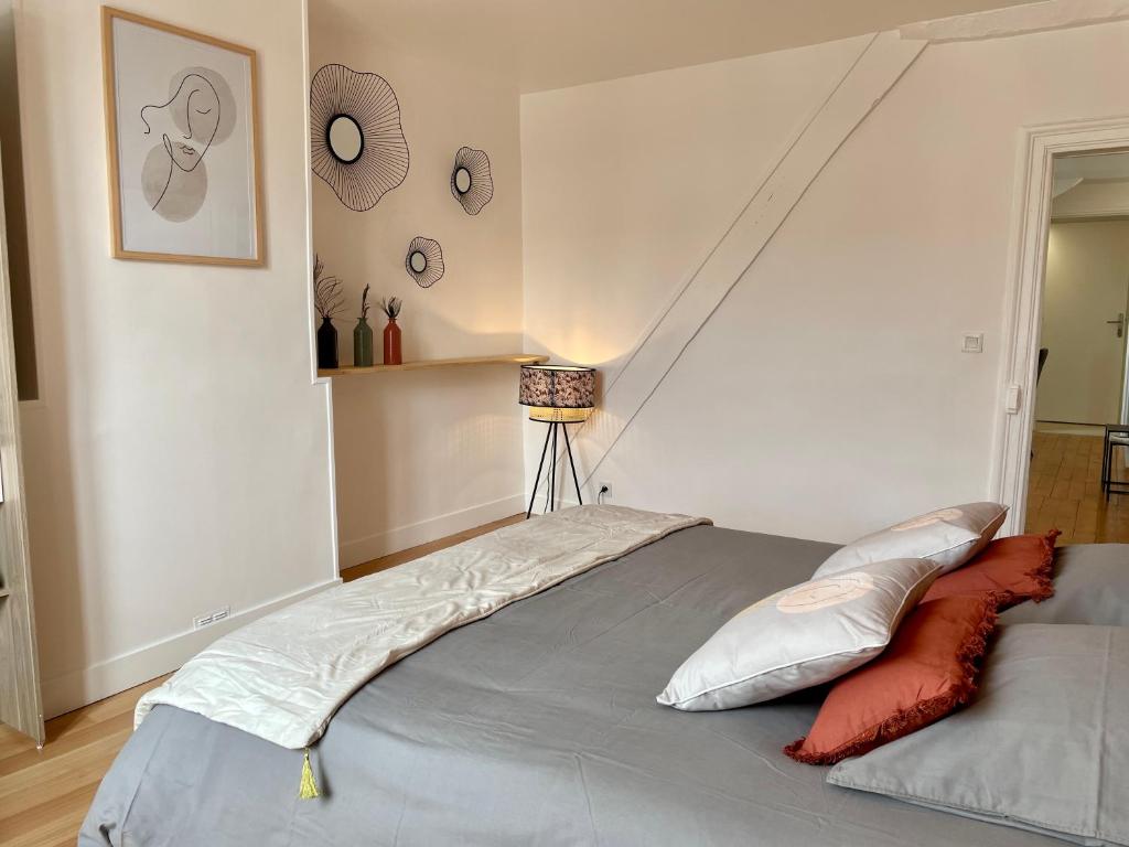 a bedroom with a large bed with at Le Cosy in Bayeux