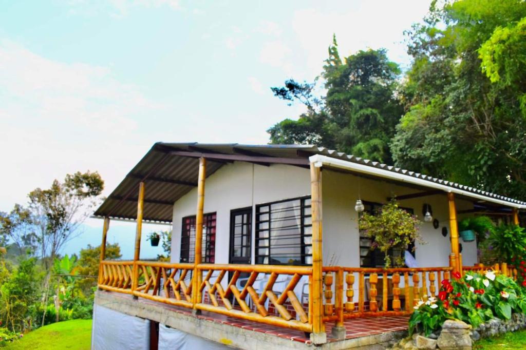 Cette petite maison blanche dispose d'une terrasse couverte en bois. dans l'établissement Saranna Cabaña, à San Agustín