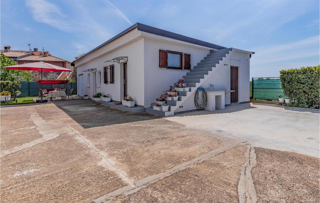 Biały dom ze schodami przed nim w obiekcie Cozy Apartment In Fazana With Wifi w Fažanie