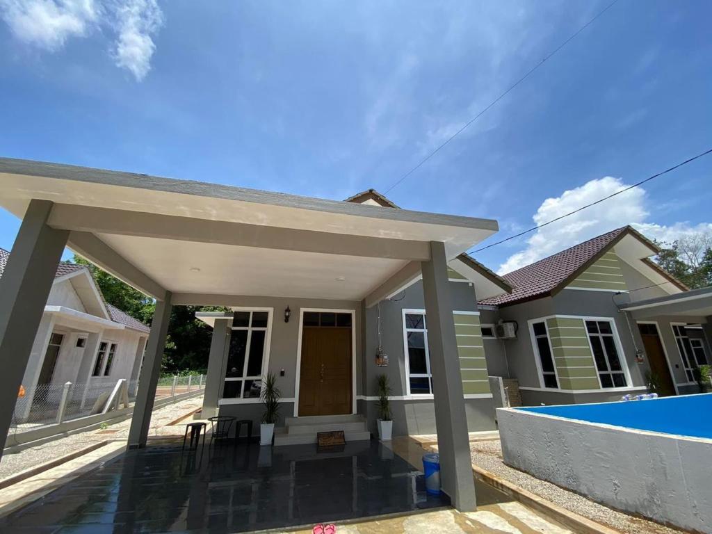 une maison avec une piscine en face de celle-ci dans l'établissement THE PINE HOUSE, à Kuala Berang