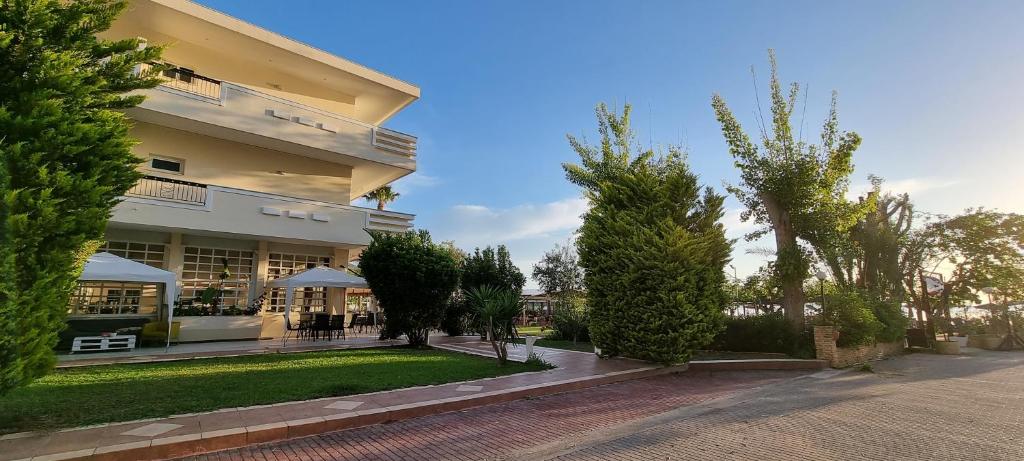 un gran edificio con árboles delante de él en Apollon Hotel, en Palaia Epidavros