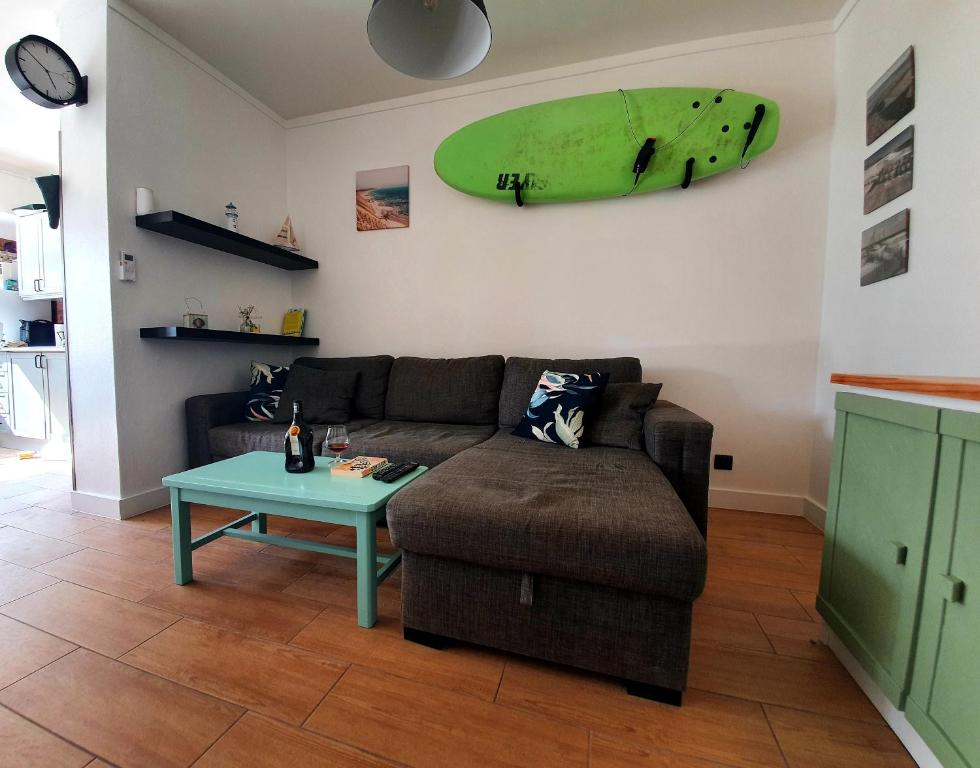 a living room with a couch and a surfboard hanging on the wall at Santos LODGE surf - 5 minutes walking to Praia da Rocha in Portimão