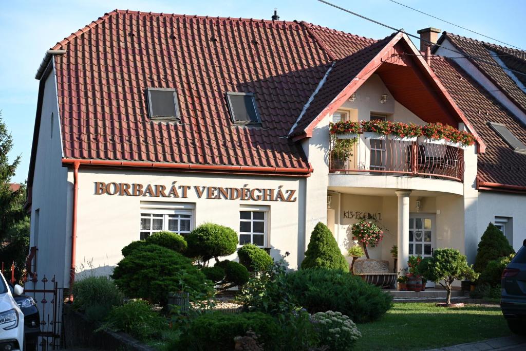 uma casa branca com um telhado vermelho em Borbarát Vendégház em Eger