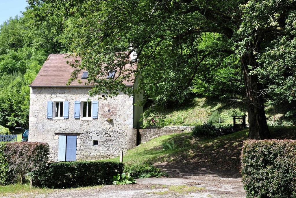 una casa de piedra en medio de un bosque en Le Moulin, en Creysse