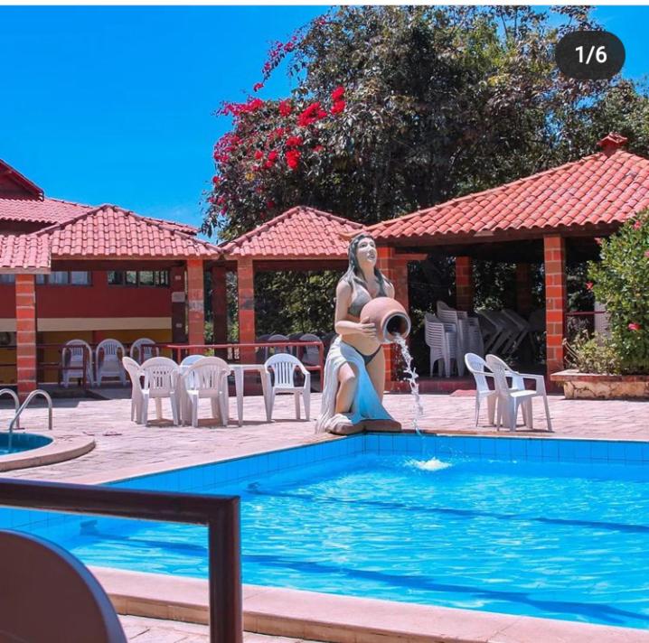a woman is sitting next to a swimming pool at Hotel Serrano in Martins