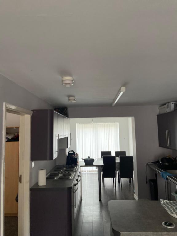 a kitchen with a stove and a table with chairs at 8 Challanor road in Yarm