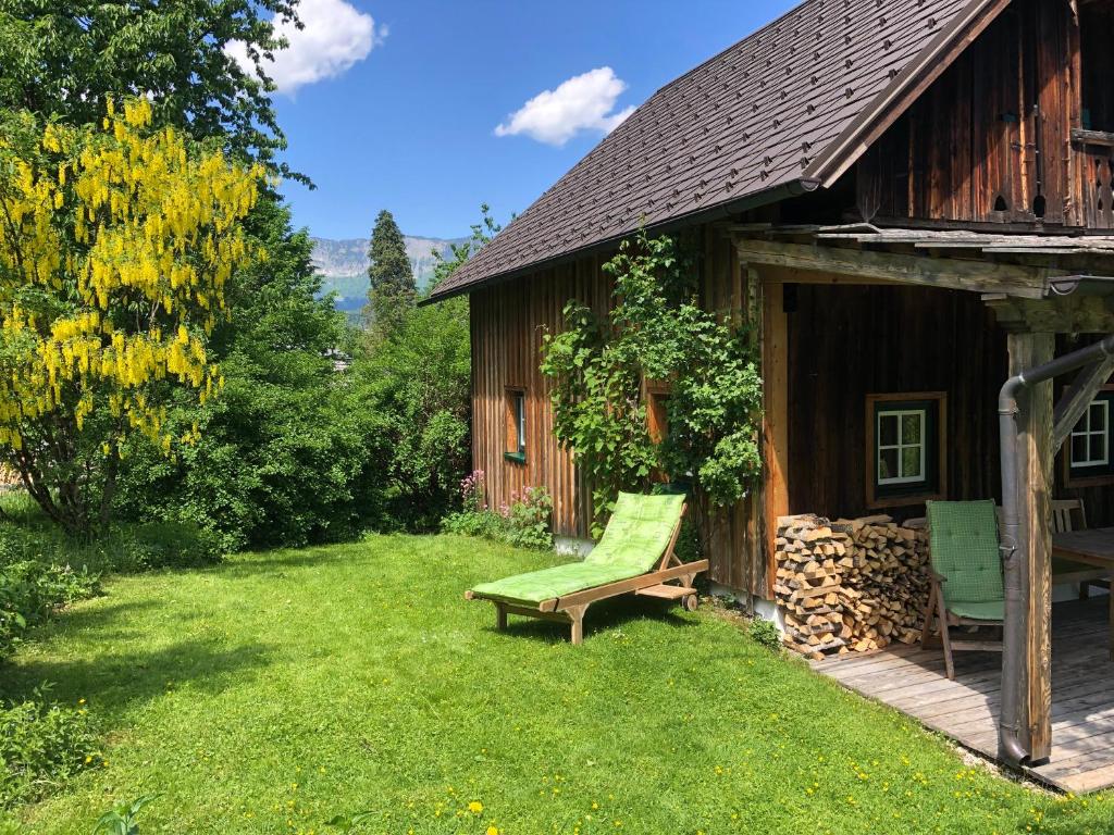 a green bench sitting outside of a building at Chalet Ramsau 8 in Bad Goisern