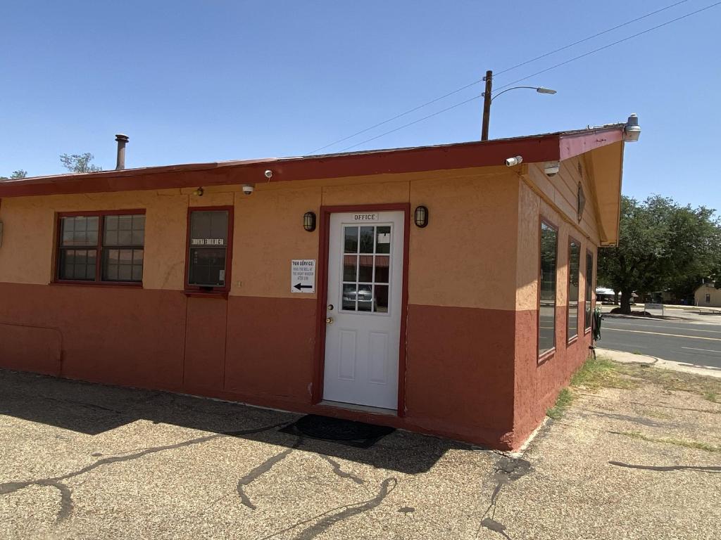 a small building with a white door on a street at Rodeway Inn in Post