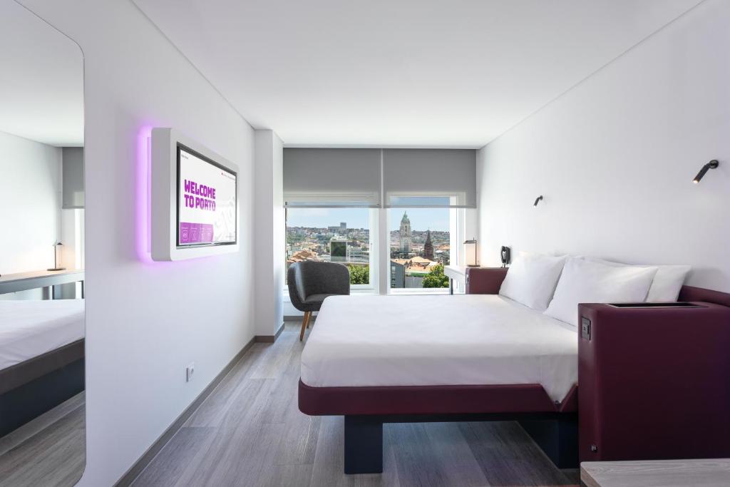 
a hotel room with a large bed and a large window at YOTEL Porto in Porto
