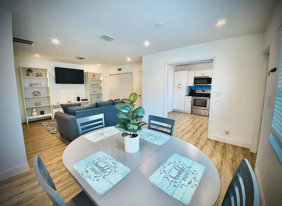 a living room with a table and a couch at Secret Serenity! Roomy! Pool! 5 min from Beach! in Deerfield Beach