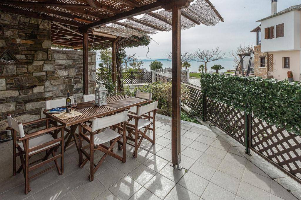 una mesa de madera y sillas en un patio en ILOI’s Villa in peaceful Village w. Private Beach, en Koropi