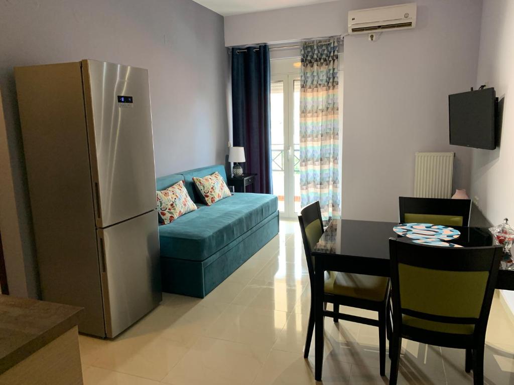 a living room with a couch and a table and a refrigerator at Christi Apartments B in Kokkini Khanion