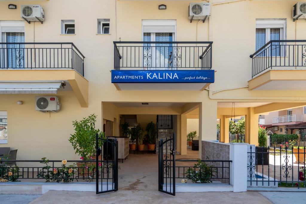 a building with a blue sign on top of it at Apartments Kalina in Leptokaria