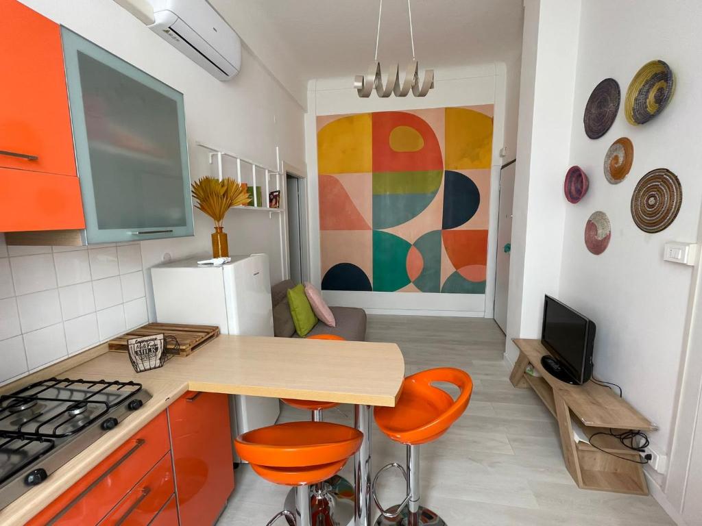 a kitchen with orange chairs and a table and a refrigerator at Casa arcobaleno in Ventimiglia