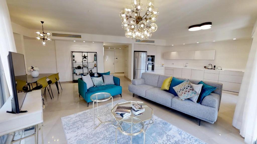 uma sala de estar com um sofá azul e uma mesa em Rental Israel-Mamila Residences 16 em Jerusalém