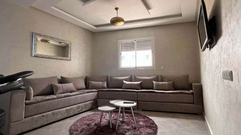 sala de estar con sofá y 2 mesas en Tiwaline Tarsime App A, en Sidi Ifni