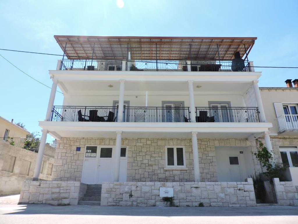 a white building with a balcony on top of it at Villa Korčula in Vela Luka